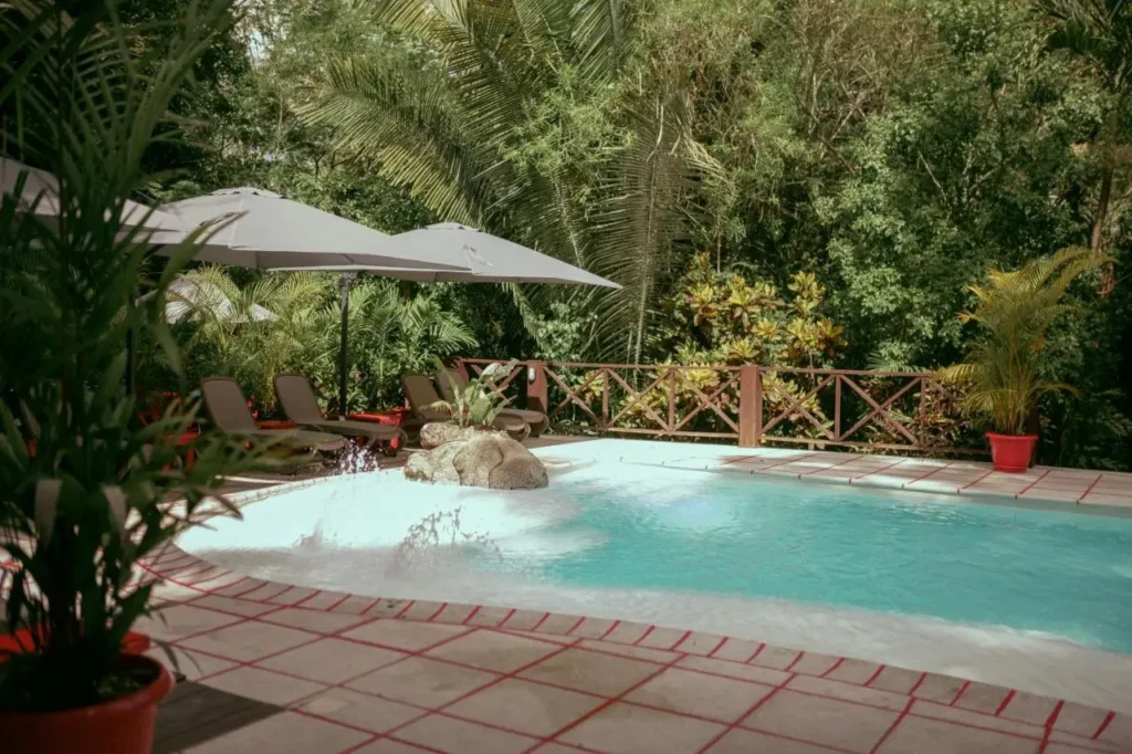 Piscina en un hotel de Tikal Petén Guatemala, con sombra de sombrillas y rodeada de exuberante vegetación tropical, ideal para relajarse