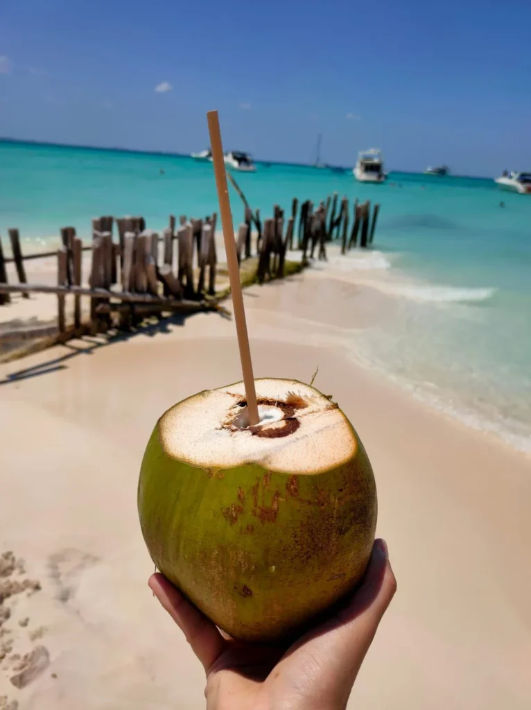 Coco fresco en Playa Norte con arena blanca y mar turquesa de fondo