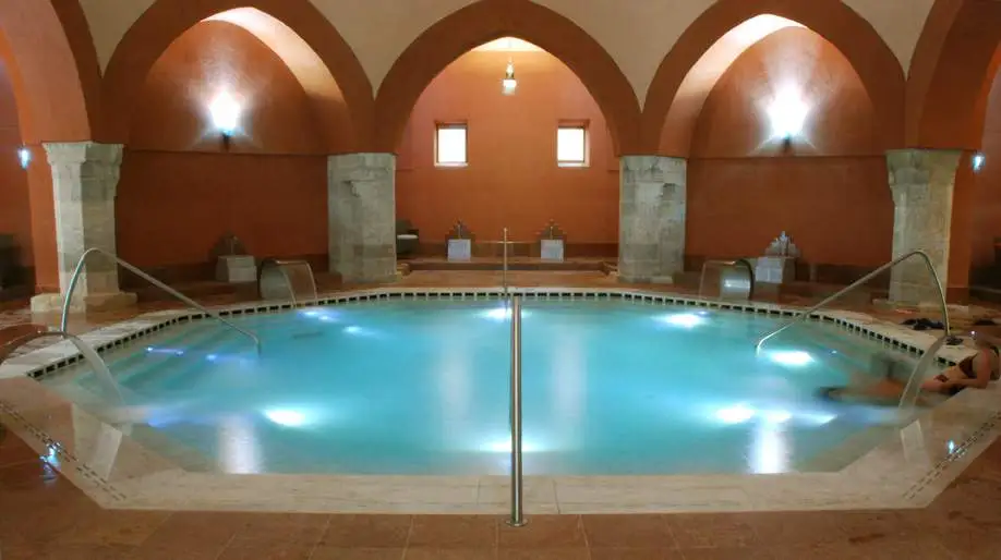 Piscina termal interior del balneario Veli Bej en Budapest, con arcos de piedra y cúpula