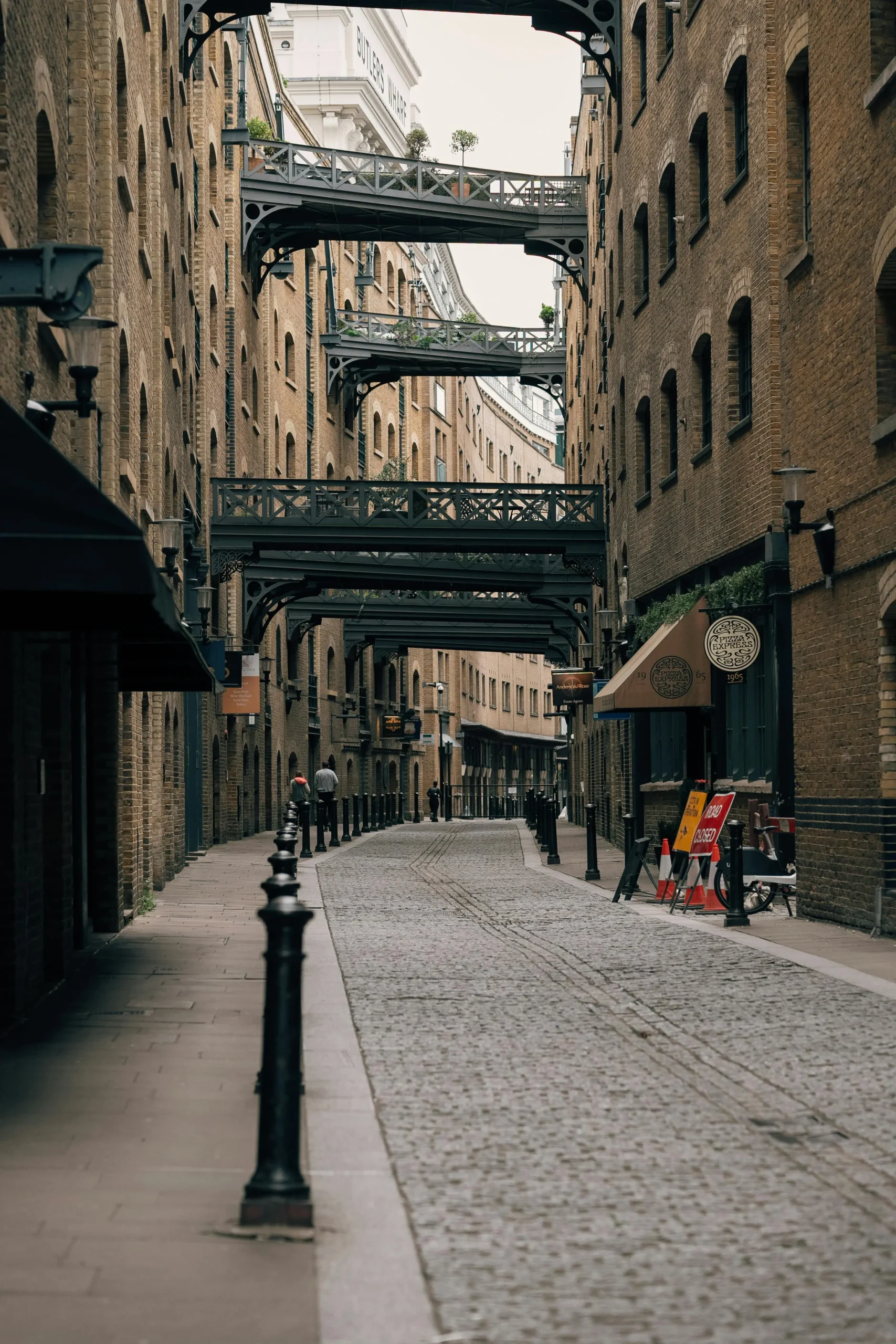 L4.22 Vista de la calle de Shad Thames, con edificios de ladrillo y pasarelas de hierro entre los pisos, mostrando el carácter industrial y pintoresco de esta zona de Londres