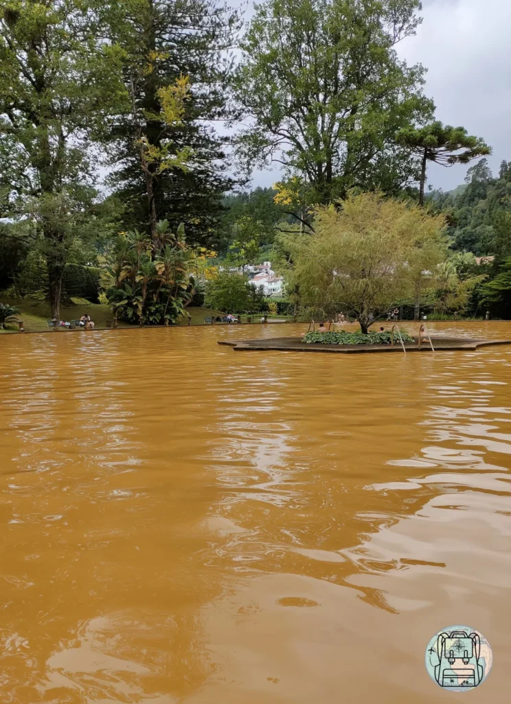 Piscina de agua termal férrea naranja en el Parque Terra Nostra de Furnas
