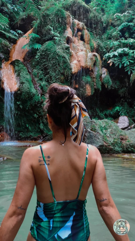 Cascada de agua caliente rodeada de helechos gigantes en el Monumento Natural Caldeira Velha